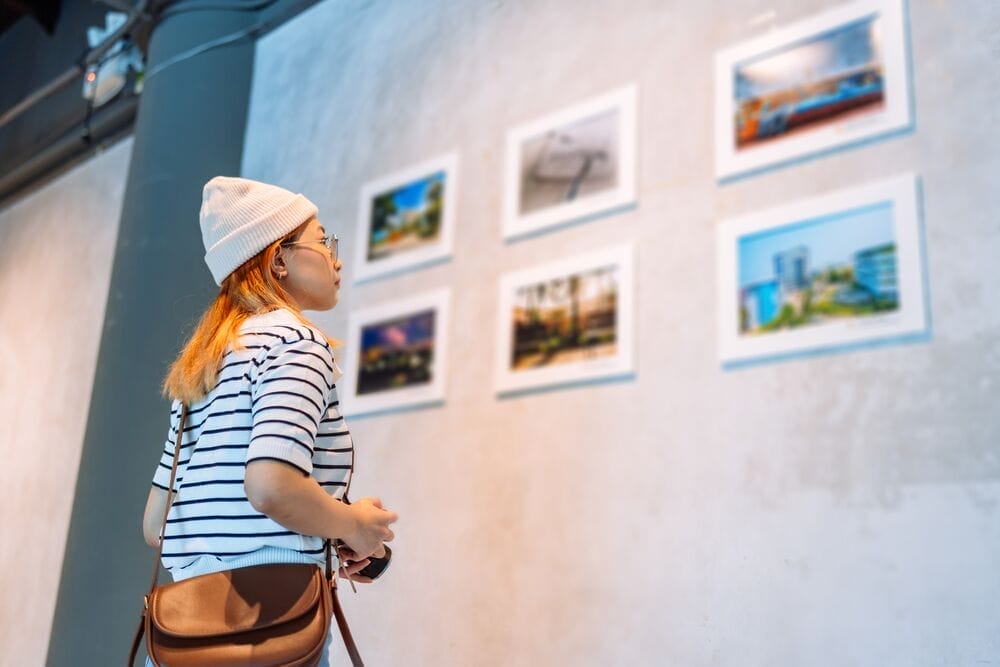 Woman visiting art gallery her looking pictures on wall watching photo frame painting at artwork museum people lifestyle concept.