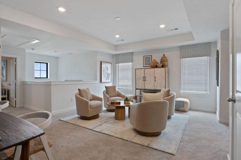 Bright living area featuring soft-toned seating, natural light, and clean contemporary finishes