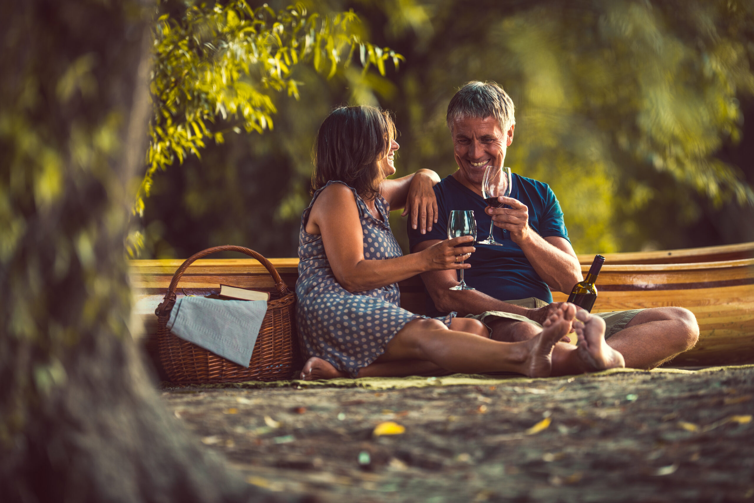 Happy senior couple drinking some wine on a picnic.